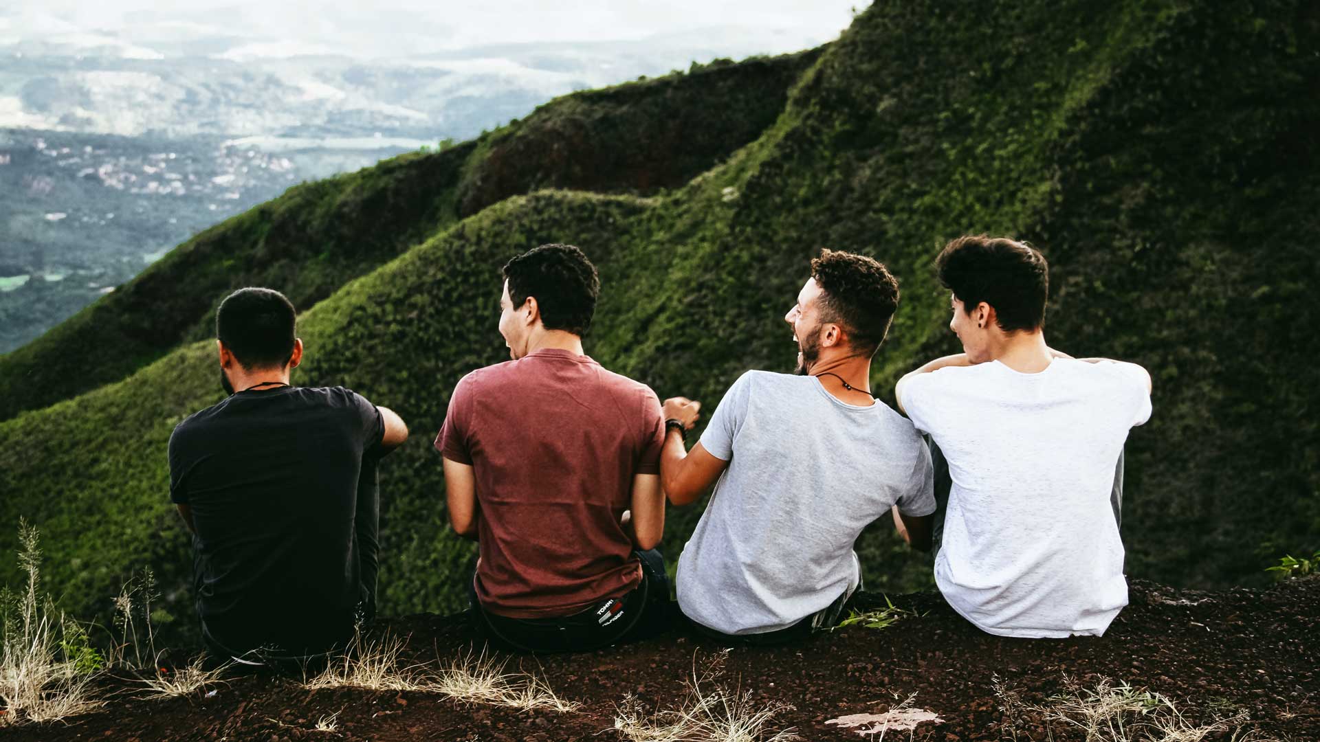 young men laughing at a mountainous overlook